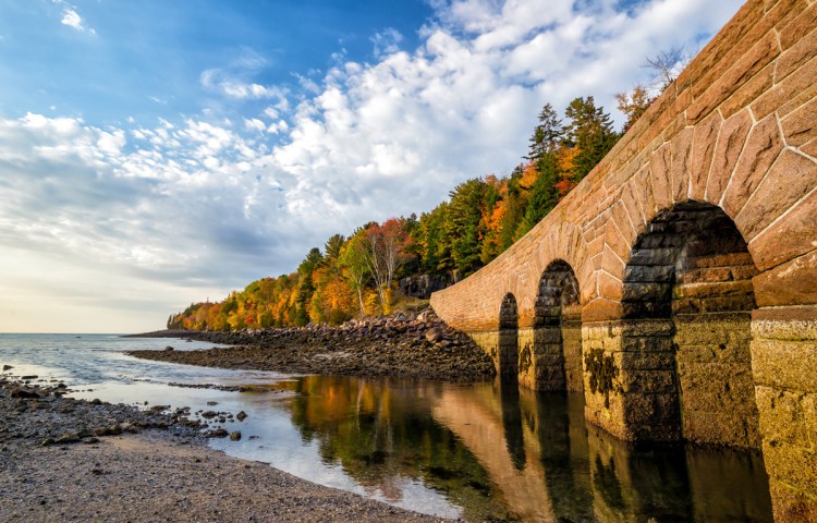 bridge reflected in water with fall foliage