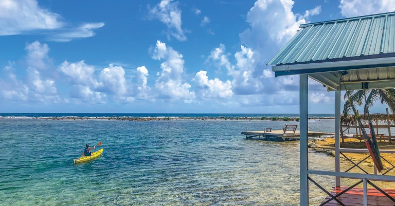 kayaker on the clear waters of tobacco caye