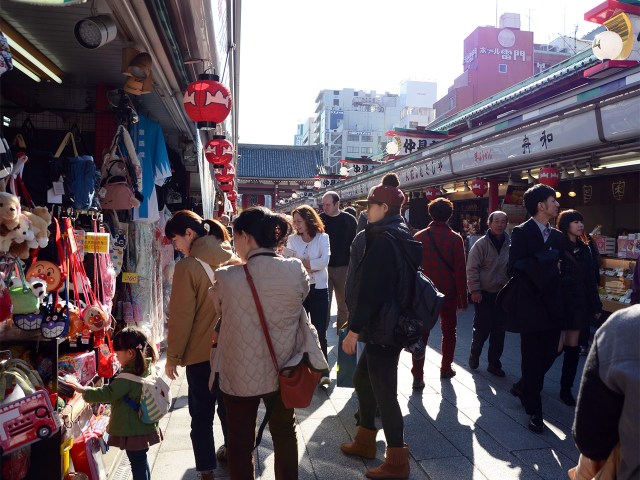 A family pauses to look at toys at an open air stall along Nakamisa shopping street.