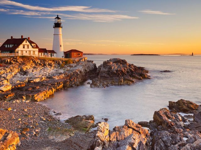 sunset on the rocky coast with a lighthouse