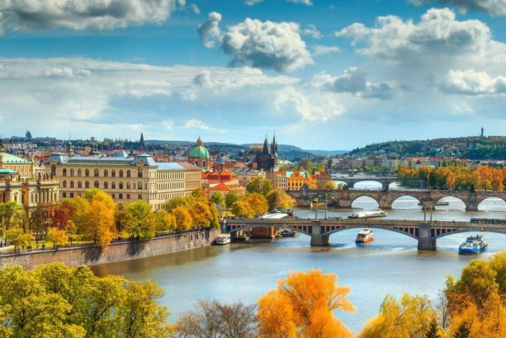 Autumn panorama of boats on the river and Prague city, Czech Republic, Europe.