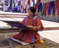 Oaxaca woman in traditional clothes sitting and weaving