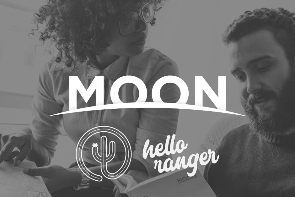 two people looking at a travel guide with logos overlaid that say moon and hello ranger