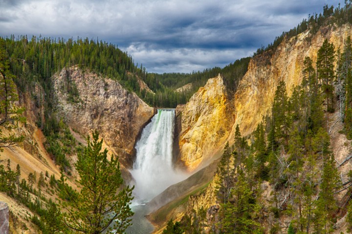 A waterfall running down the mountains in yellowstone national park.